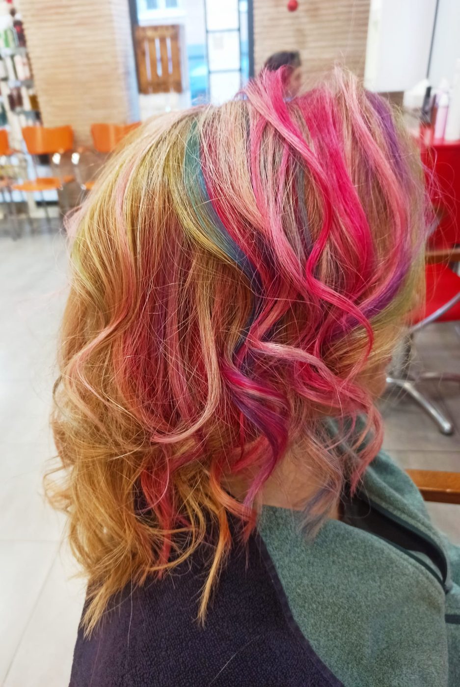 Mechas de fantasía en rosa, fucsia, verde y morado sobre base rubia