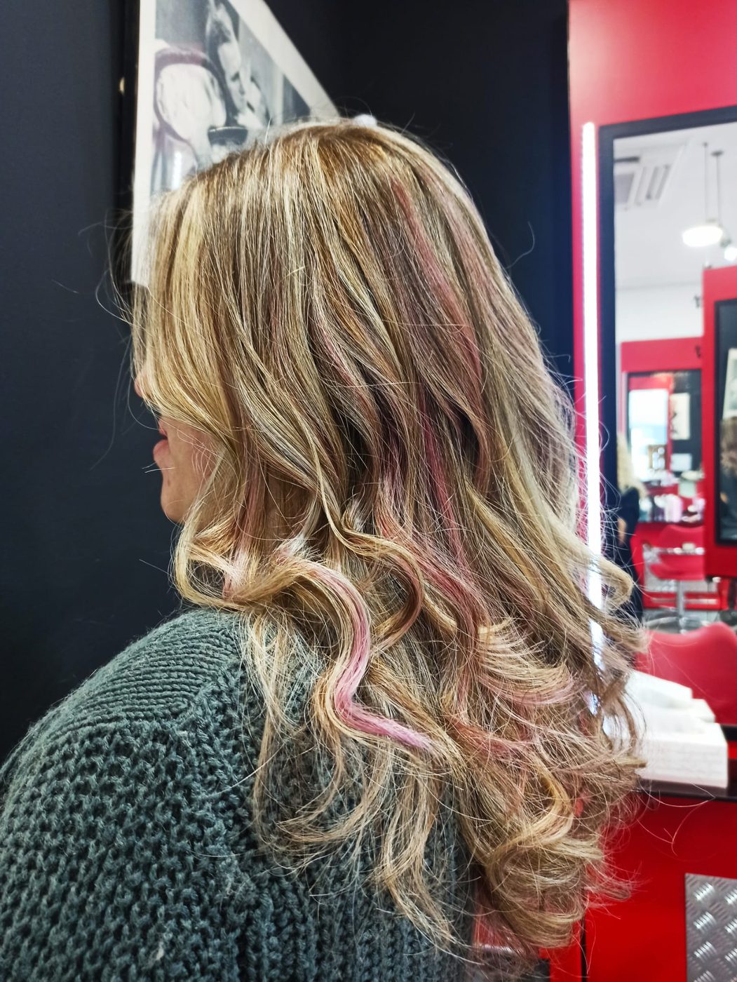 Melena rubia con ondas y mechas rosas, vista de perfil