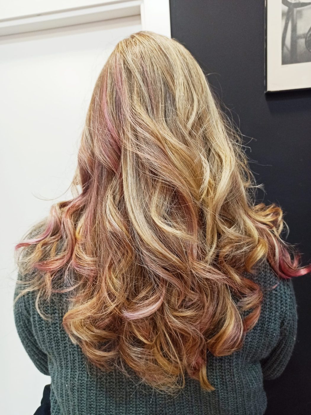 Melena rubia con ondas y mechas rosas, vista trasera