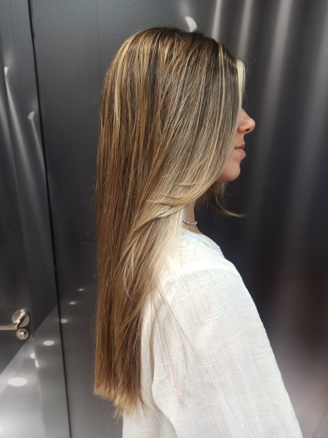 Melena larga y lisa con degradado rubio, vista de perfil