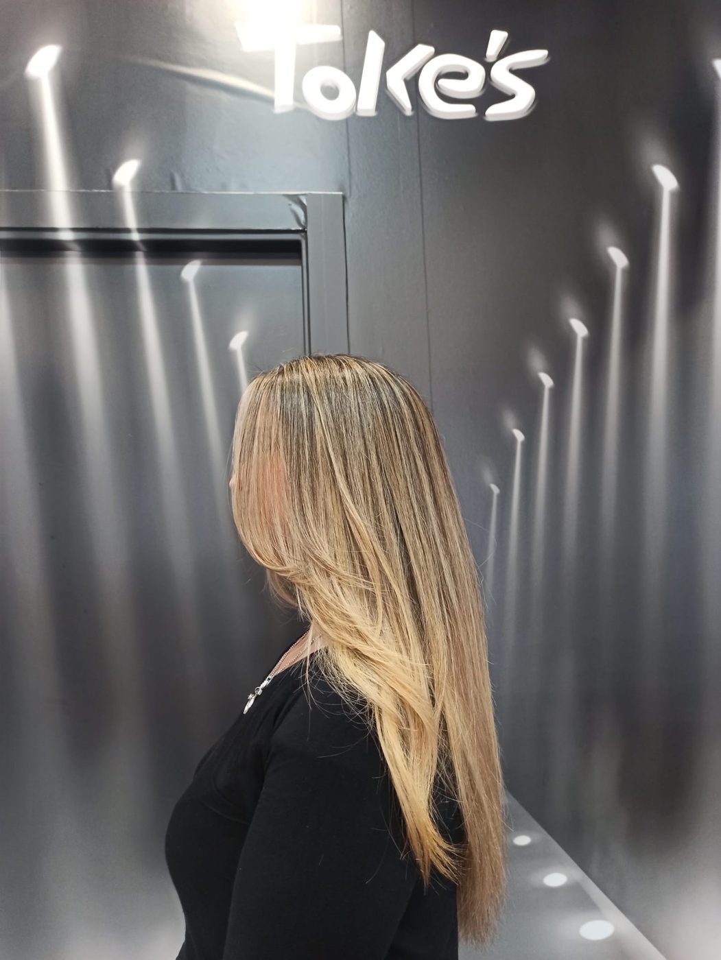 Melena rubia larga y lisa con mechas, vista de perfil