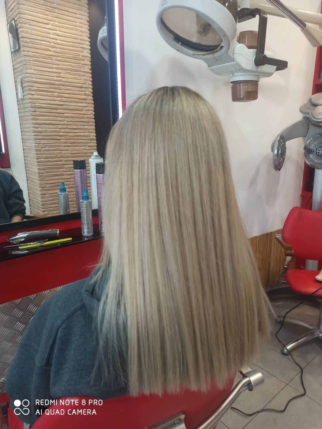 Melena rubia larga y lisa, vista trasera, en el salón Toke's
